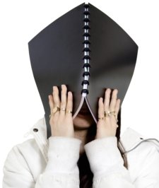 stressed female with notebook covering face