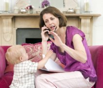 working  mom on couch with toddler